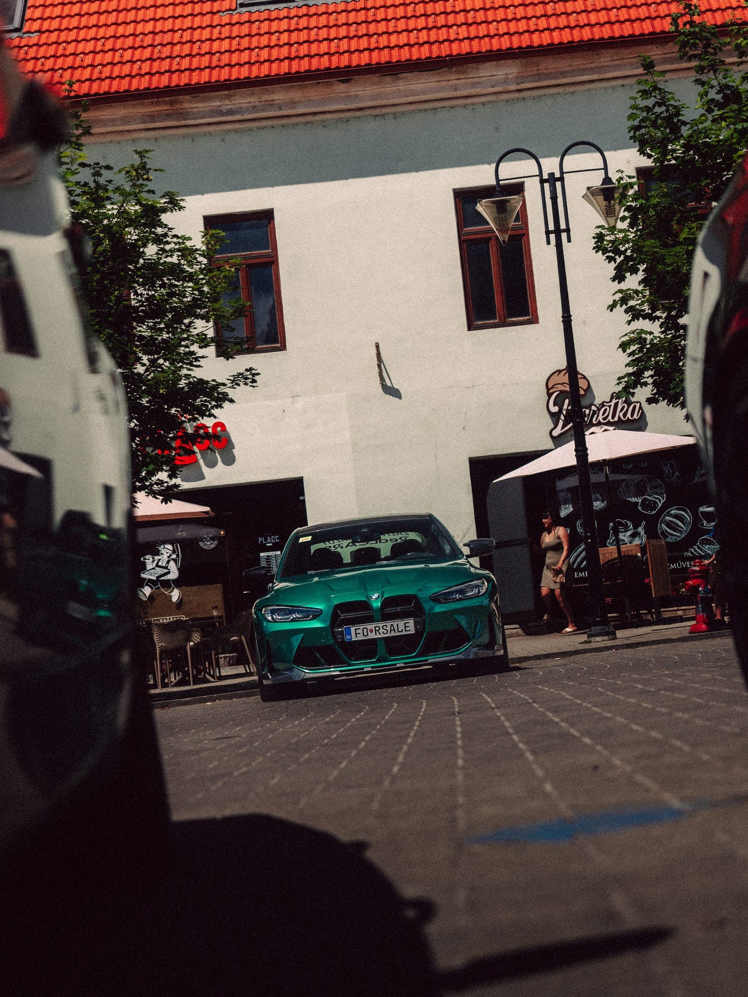Zelené BMW v úzkej uličke medzi domami