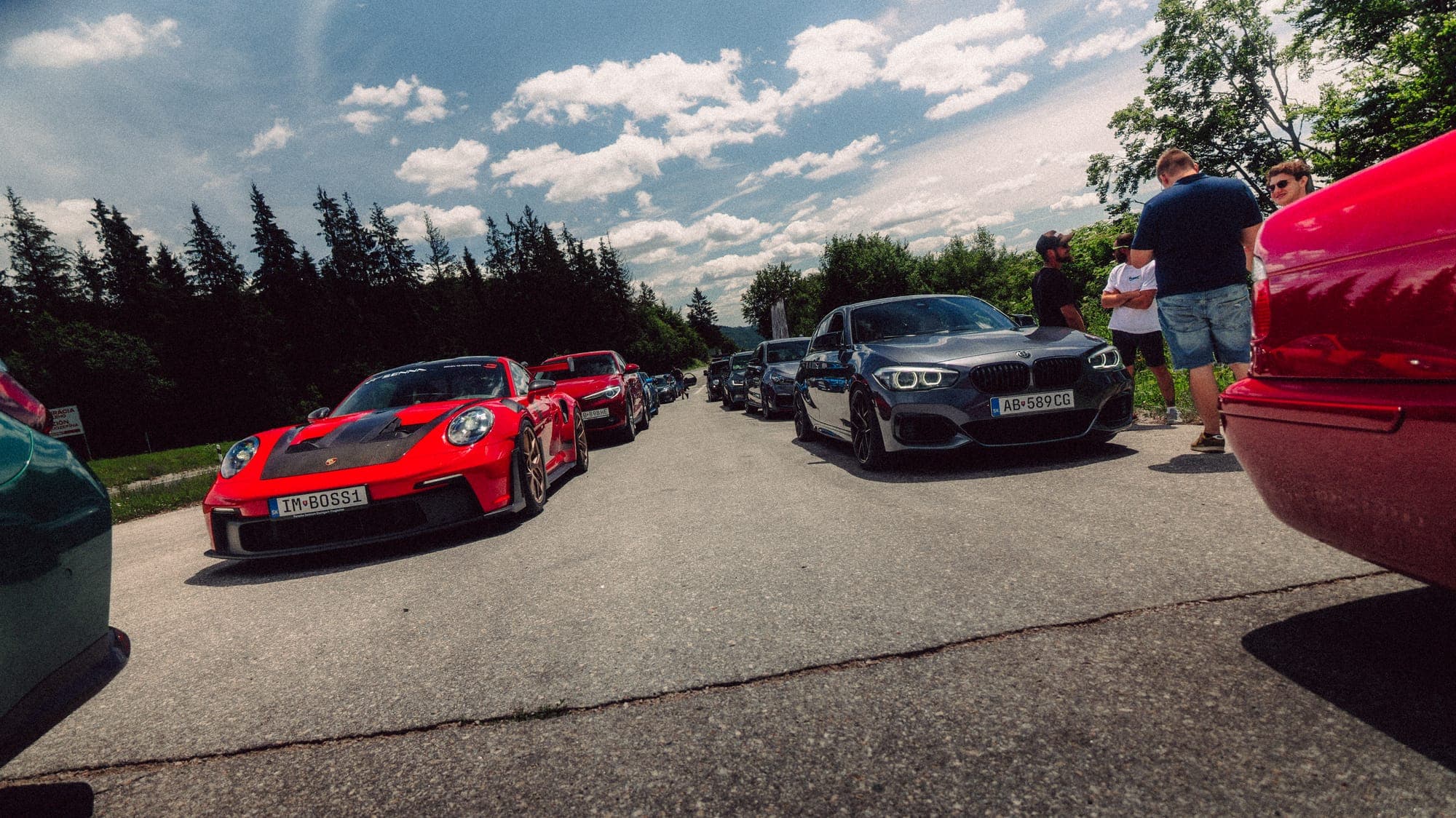 Červené Porsche medzi autami na parkovisku
