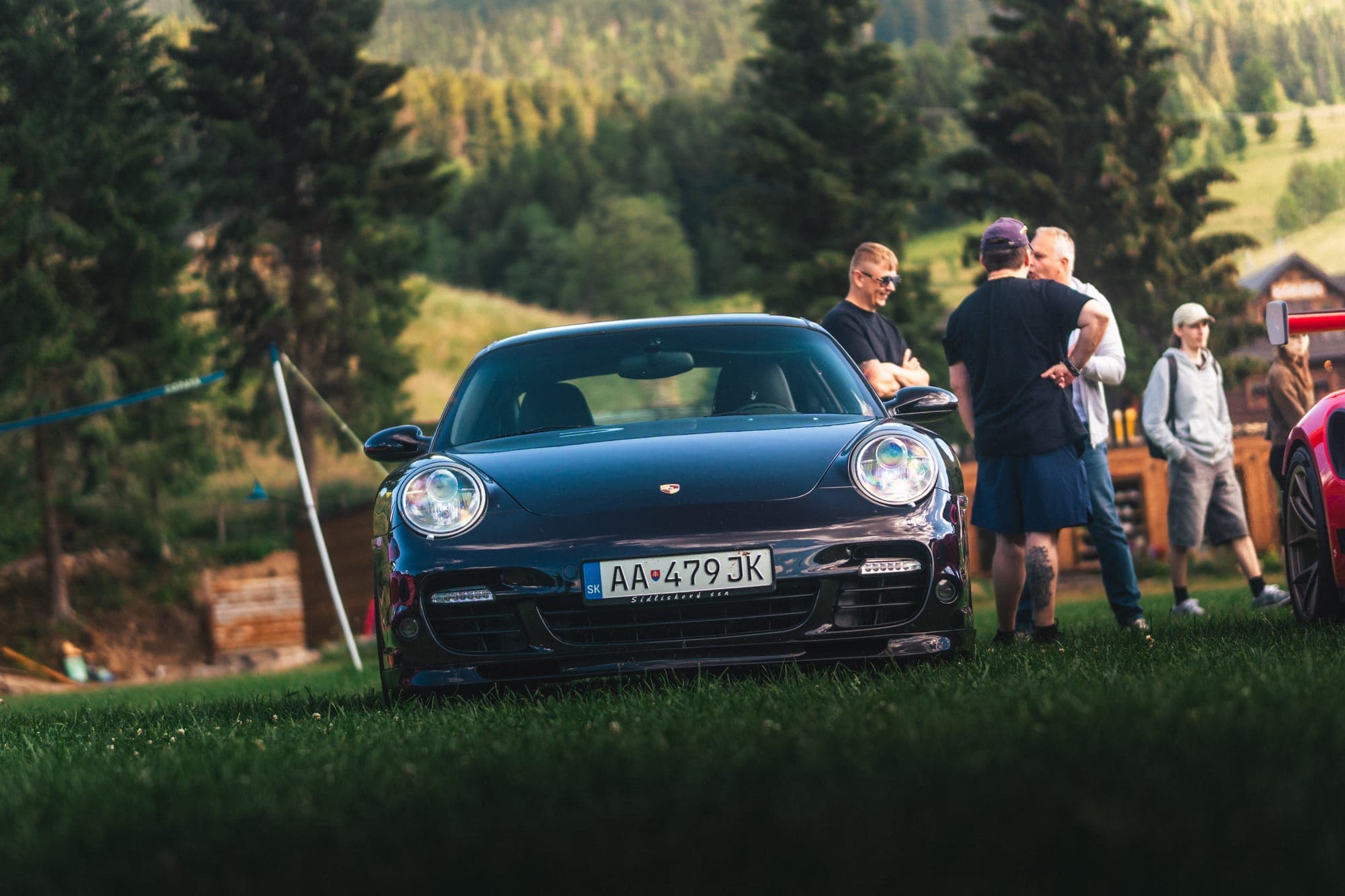 Tmavomodré Porsche a účastníci zrazu